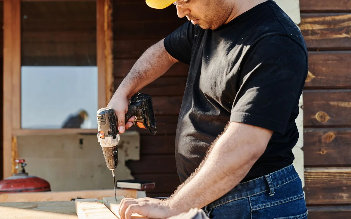 Handyman screwing down a replacement deck board