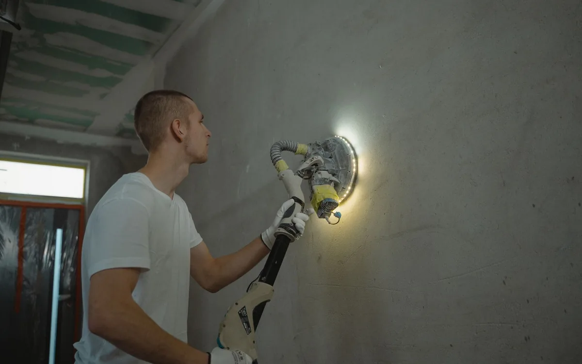 Handyman sanding a freshly patched drywall seam